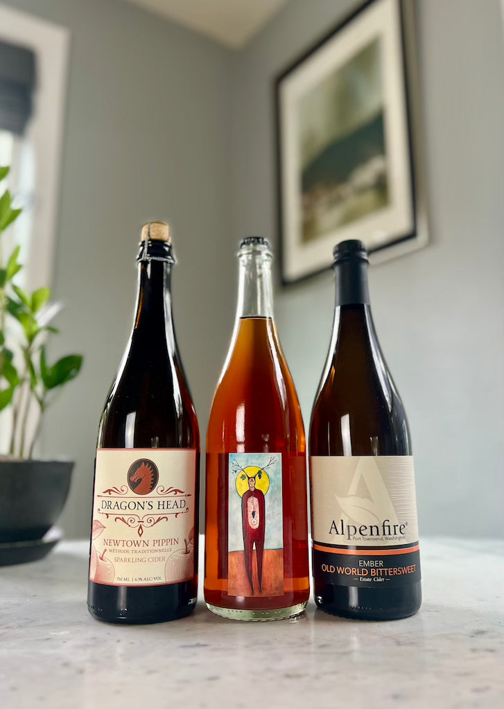 Three 750 mL bottles of cider: Dragon's Head Newtown Pippin Method Traditional , South Hill Sunlight Transformed, and Alpenfire Ember Old World Bittersweet